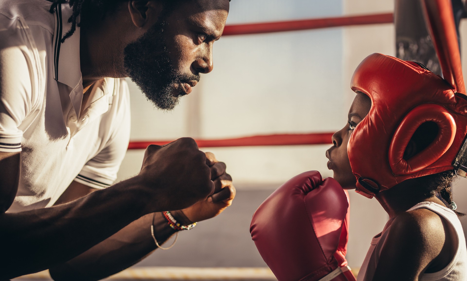 Boxing trainer teaching a kid about boxing