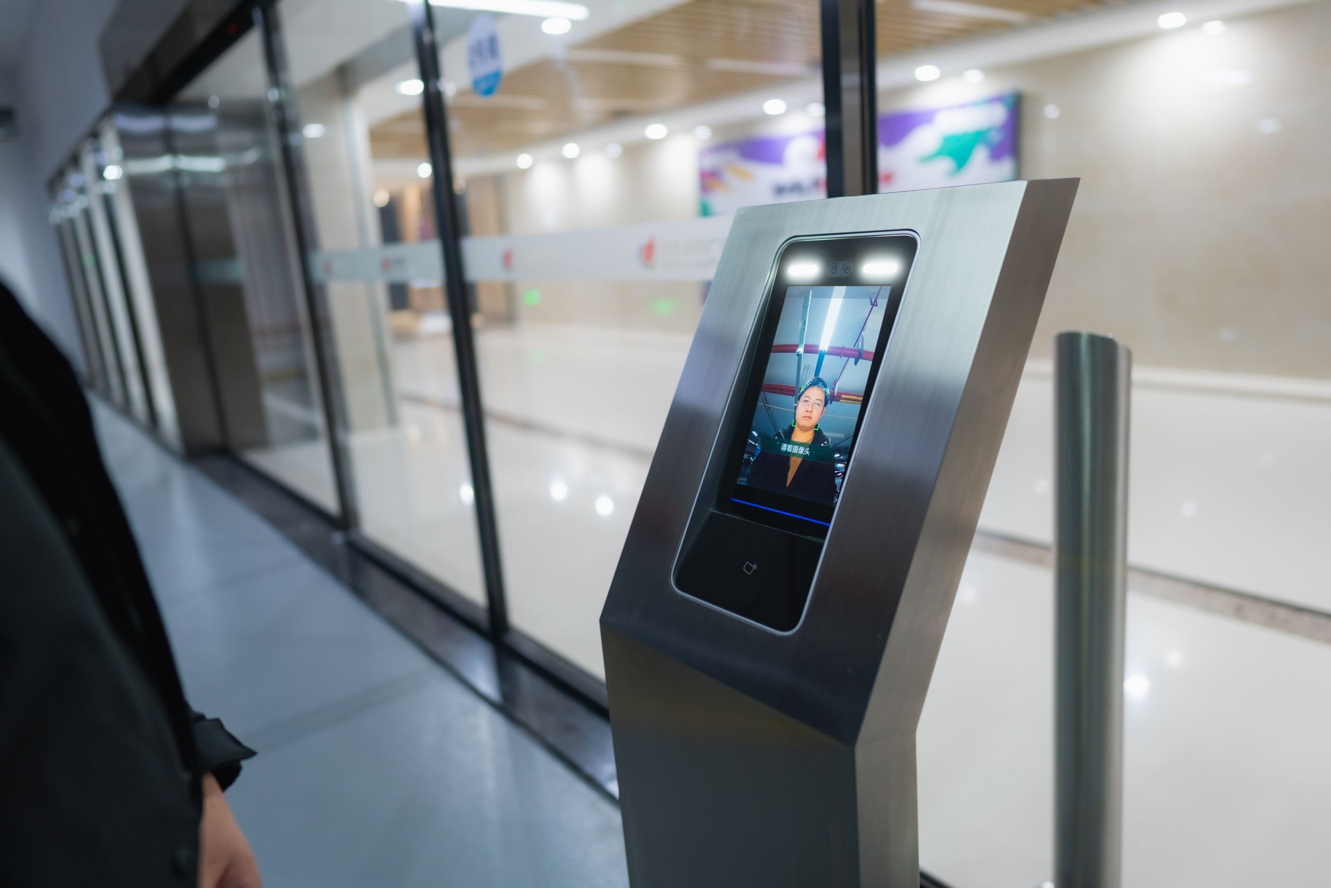 Close-up of a man using facial recognition technology to unlock a gate