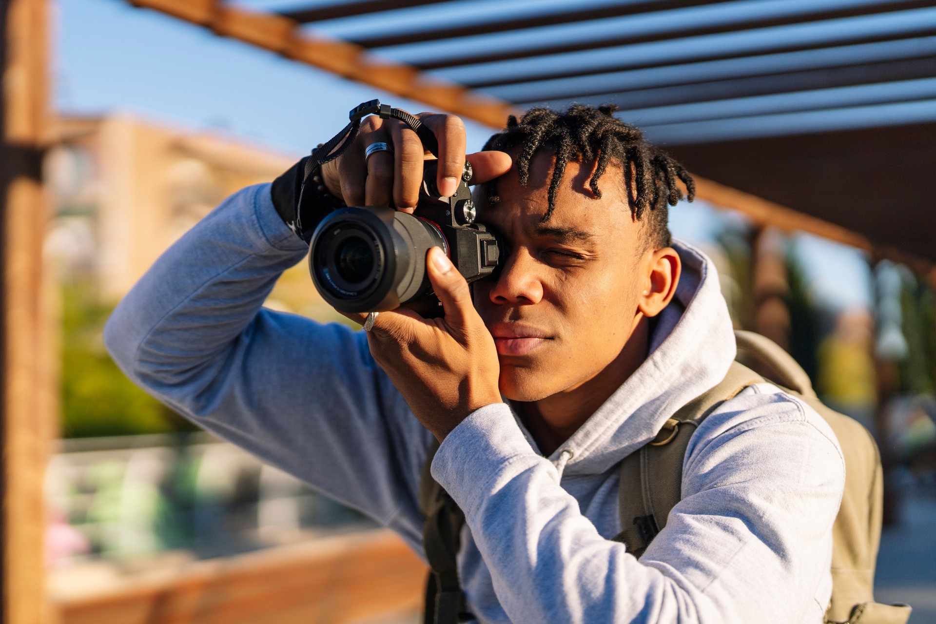 Young man using photo camera in the city on sunny day