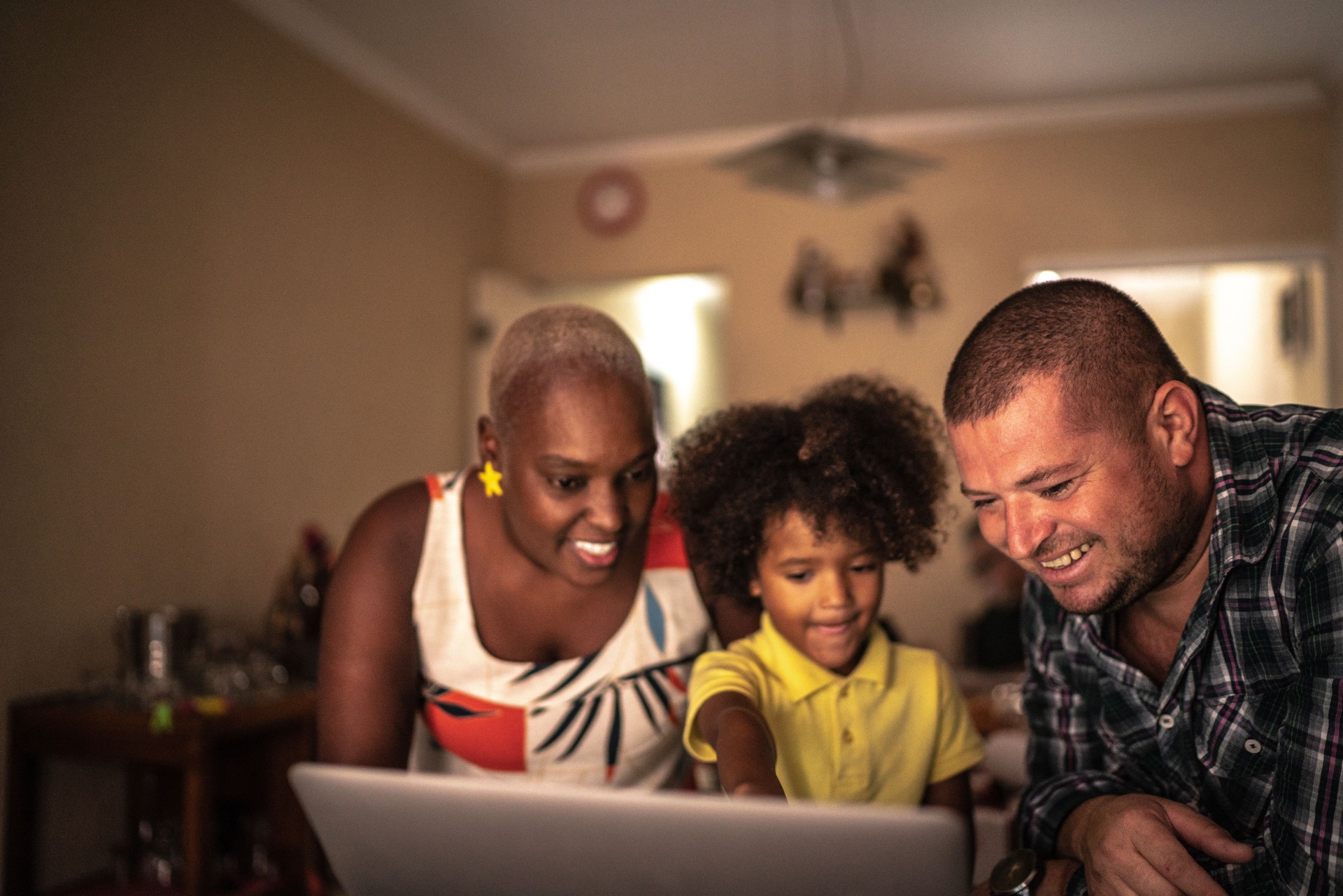 Parents with son using laptop at home