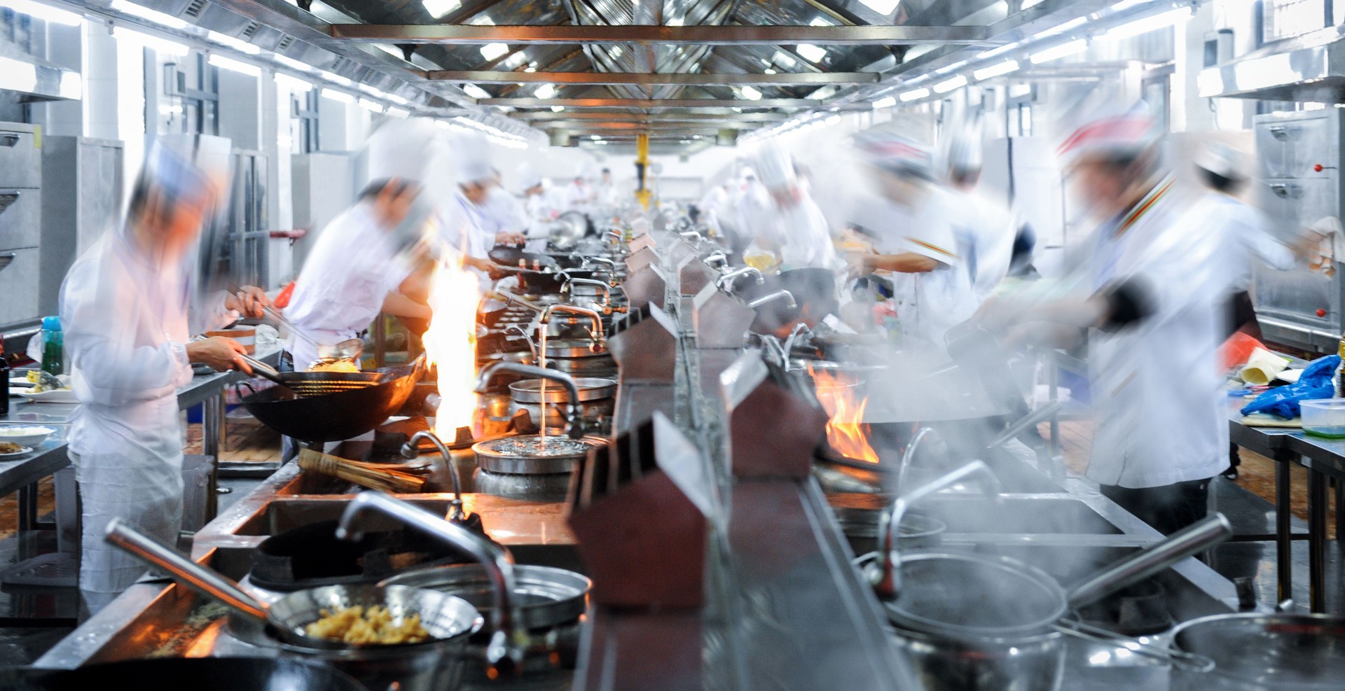 Motion chefs working in Chinese restaurant kitchen